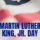 US Flag in background with blue text letters stating MLK Jr Day